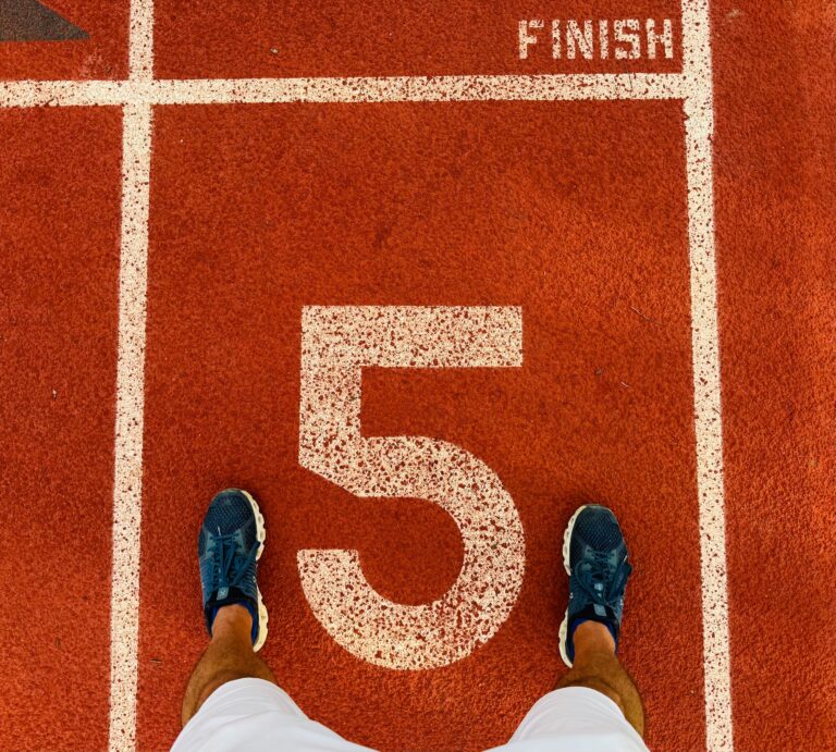 Runner's feet on track lane 5 at the finish line, symbolizing completion and success.